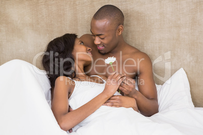 Young man offering a flower to woman