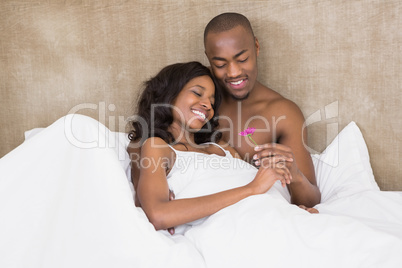 Young man offering a flower to woman