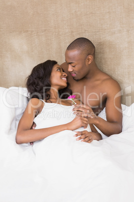 Young man offering a flower to woman