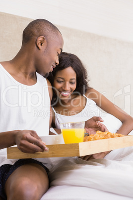 Young man serving breakfast to woman