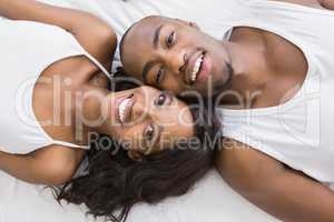 Portrait of young couple lying on bed