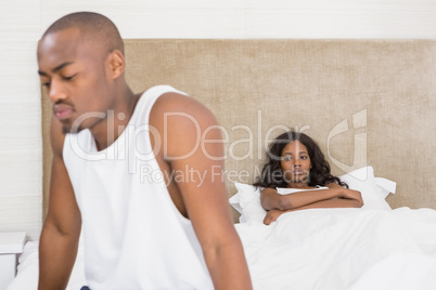 Young man sitting on bed after an argument