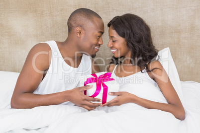 Young man presenting gift to woman