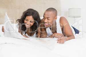 Young couple reading newspaper