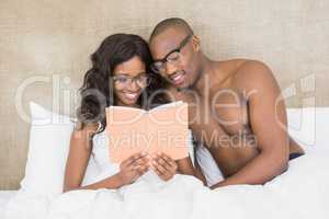 Young couple in spectacles reading book
