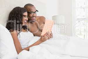 Young couple in spectacles reading book