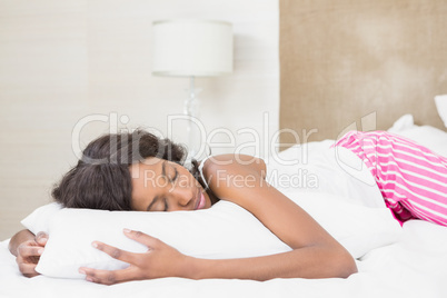 Beautiful young woman lying on bed