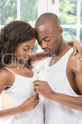 Young man offering a flower to woman