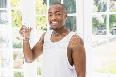 Portrait of young man holding glass of water