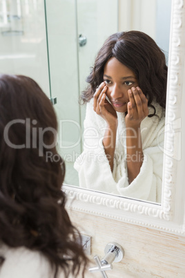 Woman checking her skin in bathroom