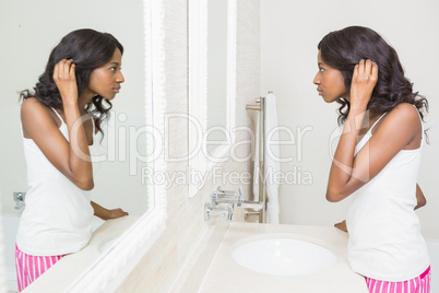 Young woman looking her self in mirror