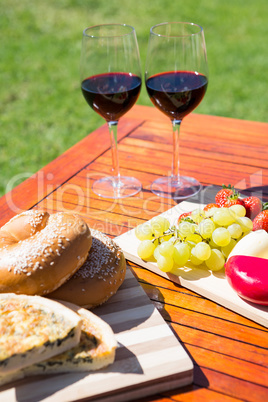 Fruit, bread and wine glass on wooden table