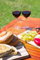 Fruit, bread and wine glass on wooden table