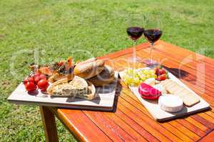 Fruit, bread and wine glass on wooden table