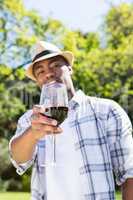Young man holding wine glass in the garden