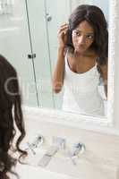 Young woman looking her self in mirror