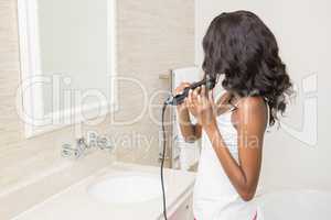 Young woman straightening hair