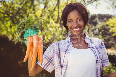 Young woman holding bunch of carrots