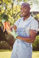 Young man holding bunch of carrots