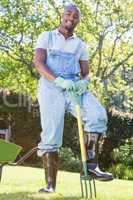 Young man posing with rake