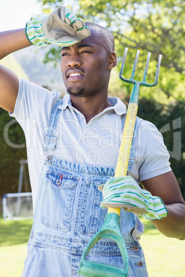 Young man posing with rake