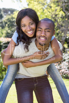 Young man giving piggyback ride to woman