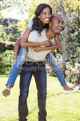 Young man giving piggyback ride to woman