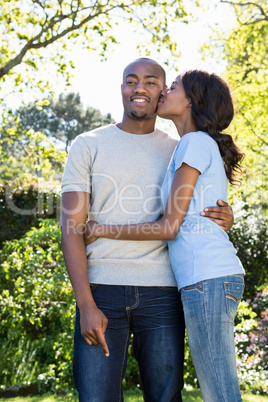 Young woman kissing man on her cheeks