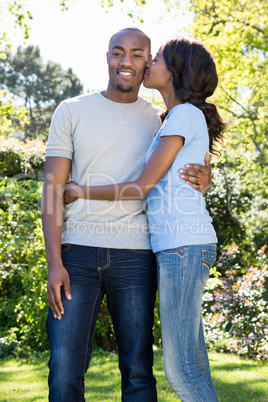 Young woman kissing man on his cheeks
