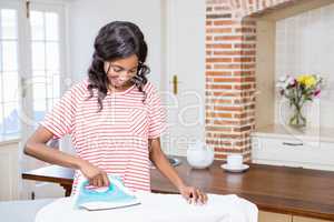 Young woman ironing her clothes