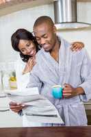 Young couple reading newspaper