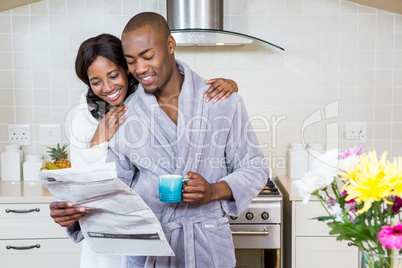 Young couple reading newspaper