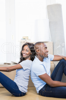 Young couple sitting together on the floor and smiling