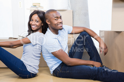 Young couple sitting together on the floor and smiling