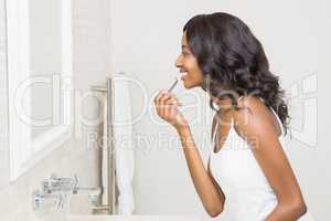 Young woman applying lipstick