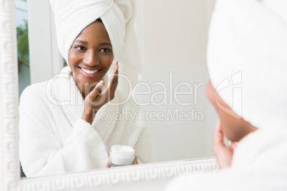 Young woman applying moisturizer