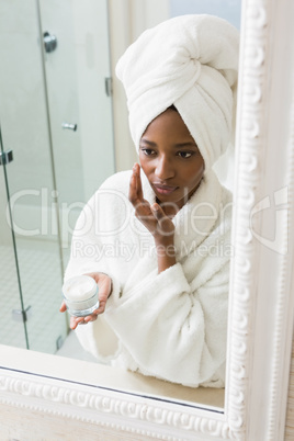 Young woman applying moisturizer