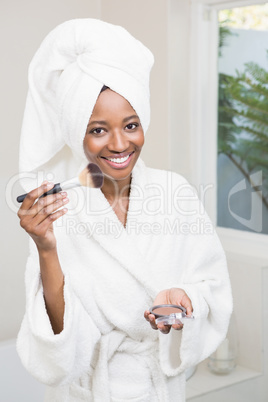 Young woman applying makeup on her face