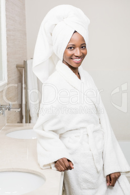 Happy young woman wearing white bathrobe