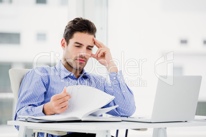 Worried businessman looking at diary Worried businessman looking at diary