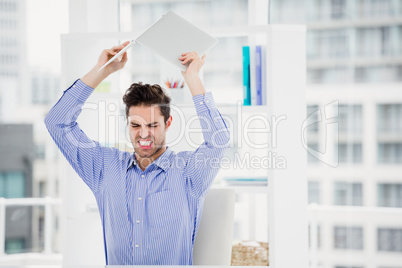 Frustrated businessman throwing laptop