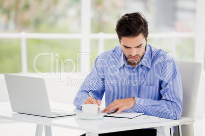 Businessman writing in diary