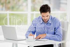 Businessman writing in diary