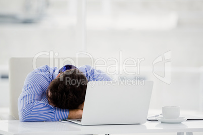 Businessman putting his head down on desk