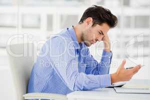 Worried businessman calculating accounts on a calculator