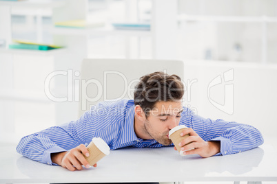 Businessman having coffee from disposable cup