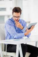 Businessman looking at document and using digital tablet