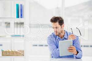 Businessman looking at document and using digital tablet