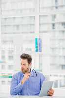 Businessman looking at document and using digital tablet