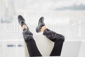 Businessman lying on ground with his feet up